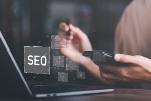 Agência de SEO: Mãos de uma pessoa digitando no teclado de um laptop, com a palavra “SEO” exibida na tela.