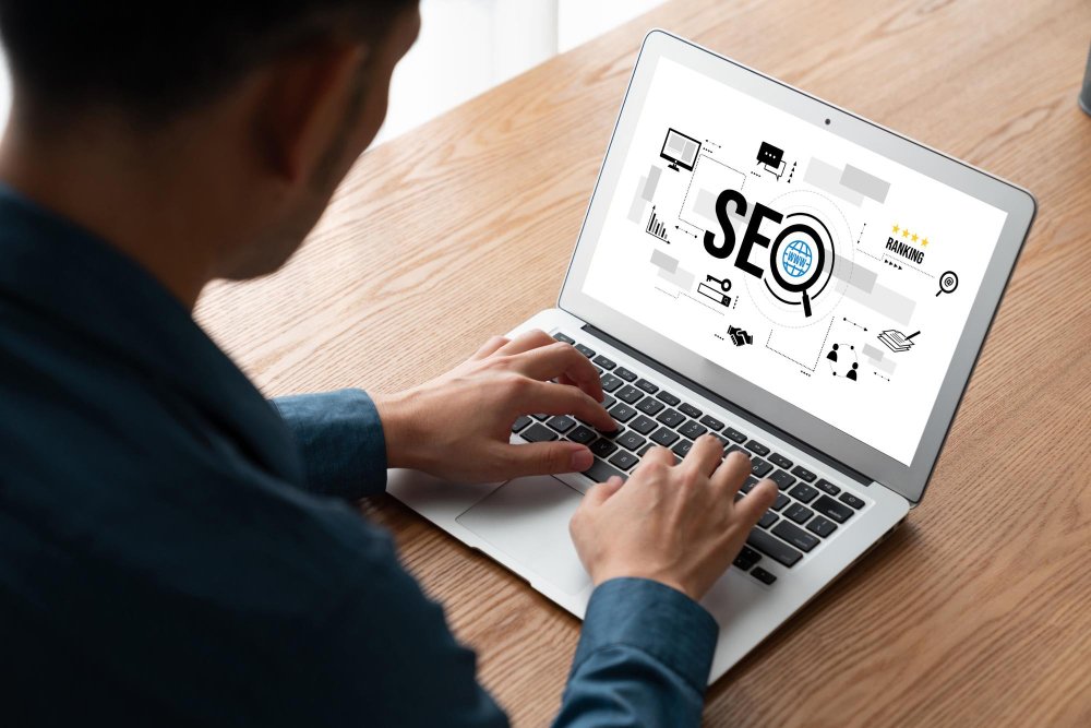 SEO copywriting: Um homem de terno trabalhando em um laptop com ícones e gráficos relacionados a SEO (otimização para mecanismos de busca) exibidos na tela.